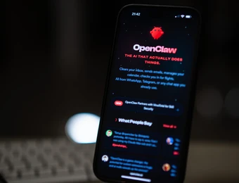 Vertikal gehaltenes Smartphone mit dunkler App-Oberfläche, rotem OpenClaw-Logo und weißen Textzeilen; unscharfer Hintergrund.