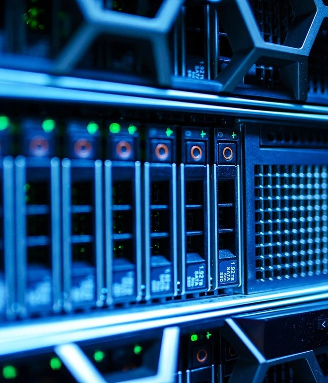 Server-Racks mit blauer Beleuchtung, Frontpaneele mit Laufwerkschächten, Lüftungsgitter und Netzwerkausrüstung.