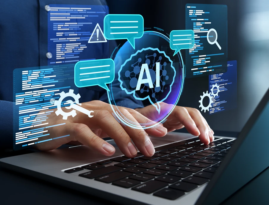 Hände tippen auf Laptop, holografische AI-Grafik mit Chatblasen, Zahnrädern und Codeblöcken über dem Display.